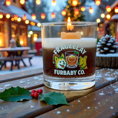 Glass candle with 'FRAGEELAY FURBABY CO. CW Candle Co. branding on a wooden table outdoors during winter. Holiday Candle. 