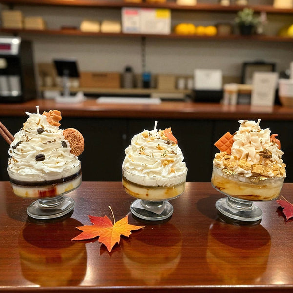  Three dessert cups fall candles with whipped wax and cookie embeds on a wooden counter in a cafe setting hand poured by CW Candle Co. 
