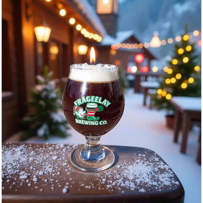 Glass of dark beer holiday candle with foam on a wooden table outdoors at night, featuring Frageelay Brewing Co. branding by CW Candle Co. North Carolina 